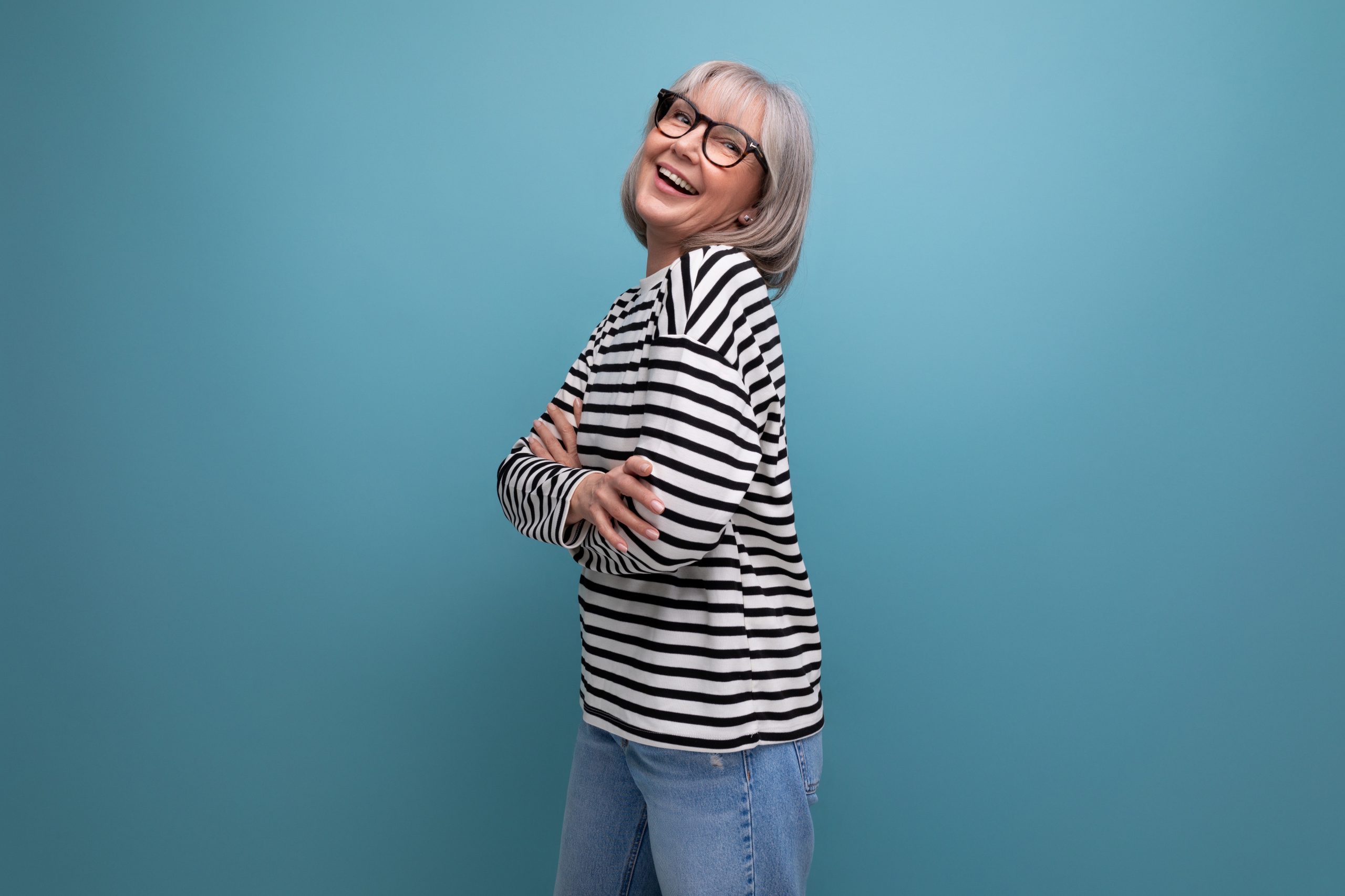 a well-groomed middle-aged woman in a fashionable image is flirting on a bright studio background